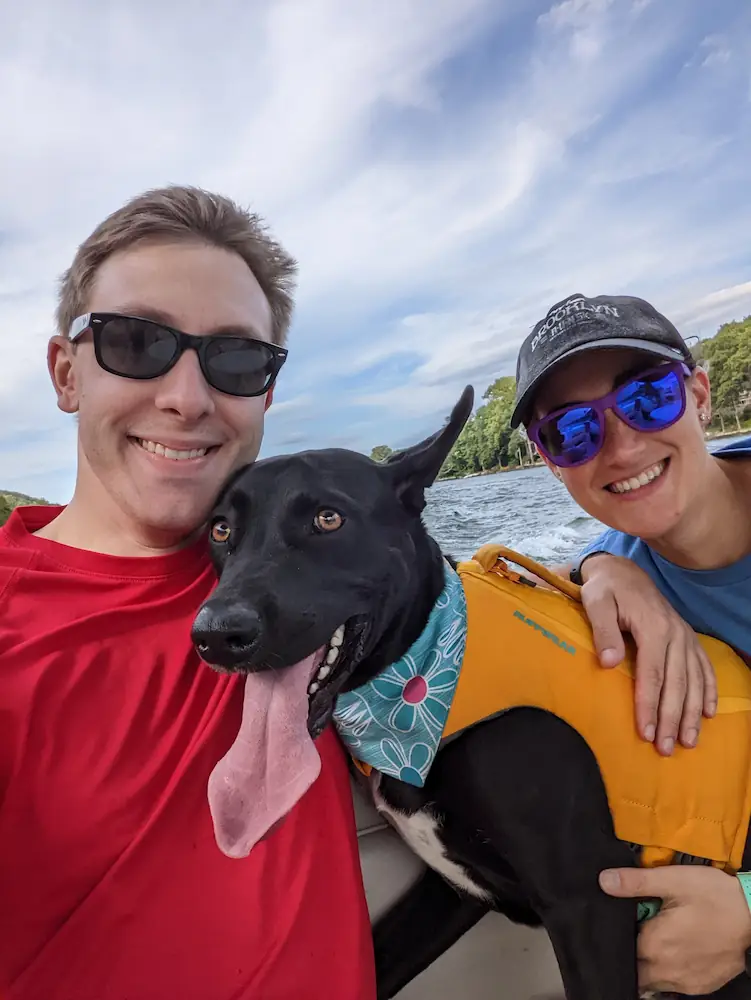 Danielle, Quentin, and Gracie out on the boat with Gracie's ears flapping in the breeze.