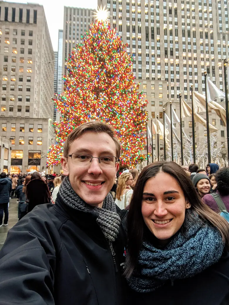 Danielle and Quentin in front of the Christmas tree at Rockefeller Center behind them.