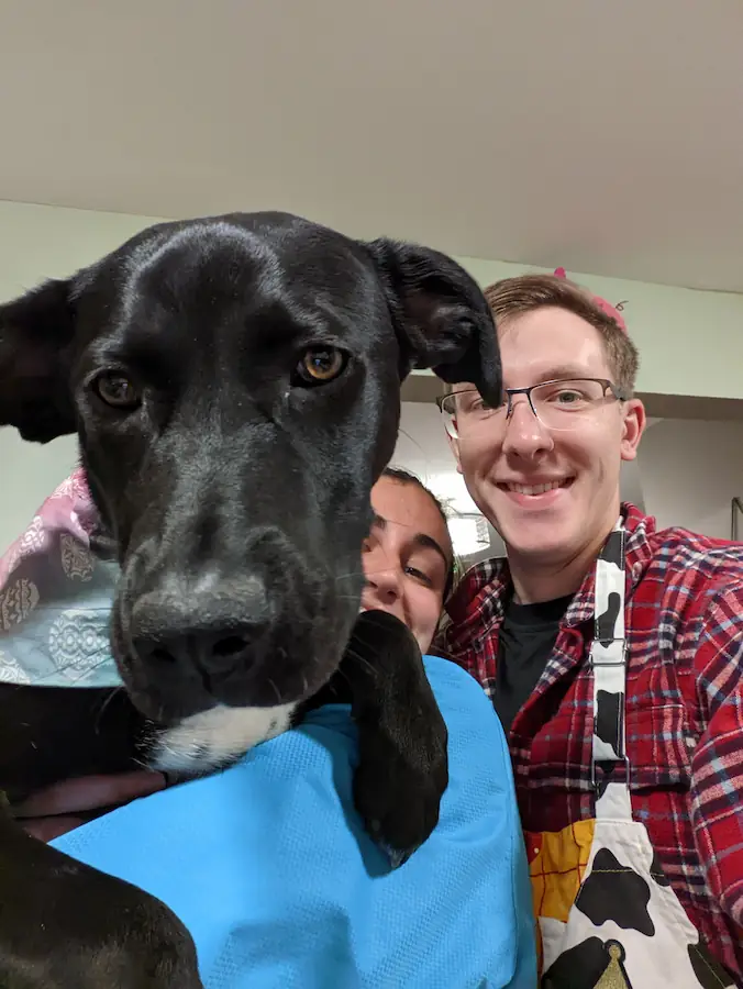 Danielle, Quentin, and Gracie in the kitchen. Danielle is holding Gracie up to the camera.