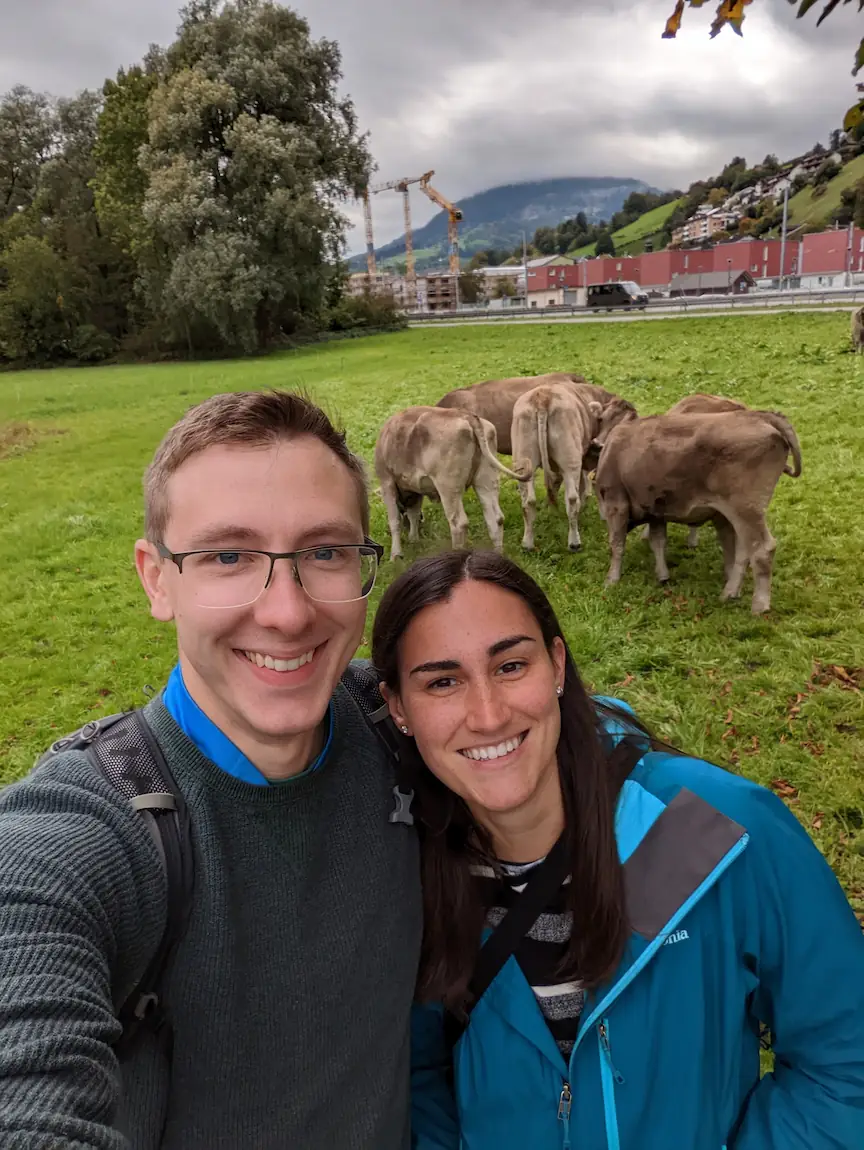 Danielle and Quentin laughing while taking a selfie in front of a bunch of cow butts.