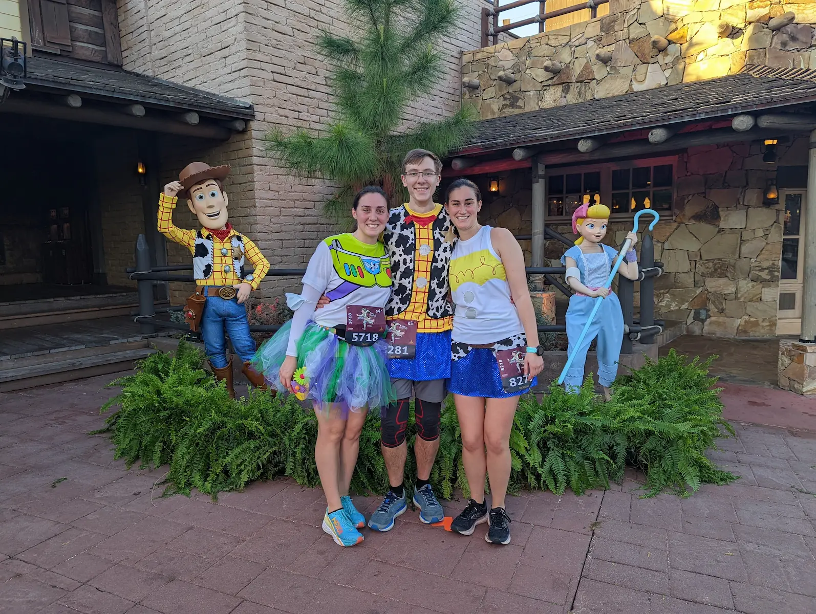 Danielle, Quentin and Emily dressed up as Toy Story characters during the half marathon, in front of Woody and Bo Peep.