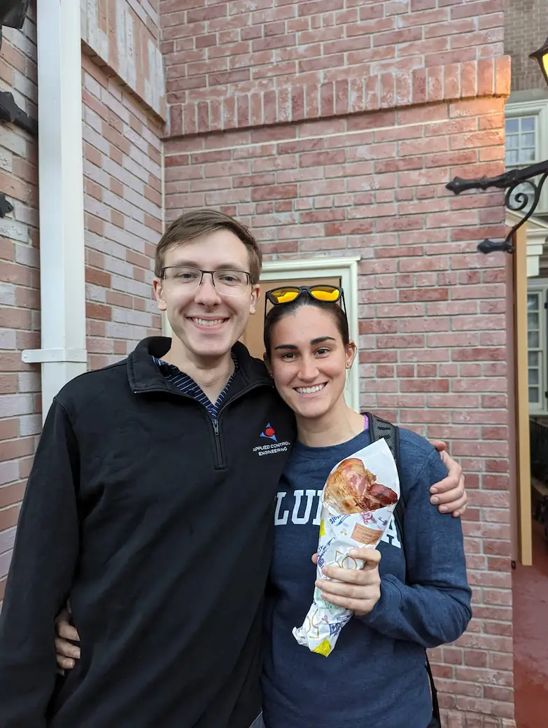 Danielle and Quentin at Disney, where Danielle is holding a gigantic turkey leg.